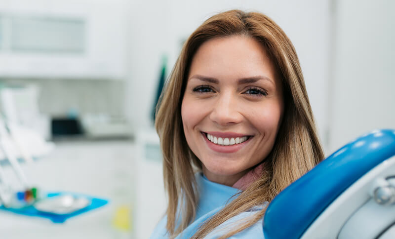 Person smiling in a dental chair, with a focus on their bright expression.